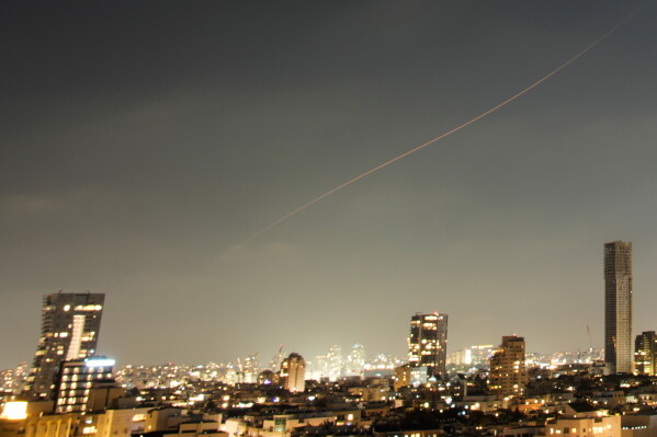 A projectile streaks through the sky over central Israel during an Iranian missile attack, Sunday, June 7, 2026. (AP Photo/Ohad Zwigenberg)