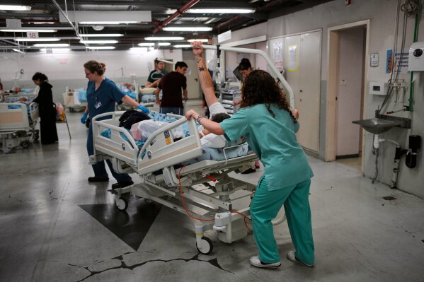 Medical staff transfer patients to a protected underground facility following an Iranian missile attack, at Ichilov Hospital in Tel Aviv, Israel, Monday, June 8, 2026. (AP Photo/Ohad Zwigenberg)