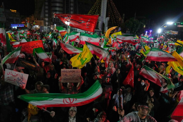 Pro-government Iranian demonstrators wave flags from Iran and Lebanon's Hezbollah in Tehran, Iran, Sunday, June 7, 2026. (AP Photo/Vahid Salemi)