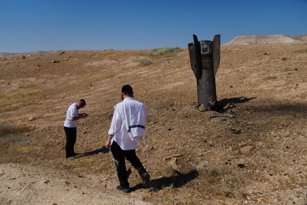 People take photos of the wreckage of an Iranian missile that landed near the West Bank city of Jericho Monday, June 8, 2026. (AP Photo/Mahmoud Illean)