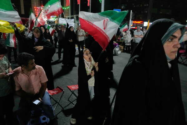 A girl waves an Iranian flag in a pro-government gathering in Tehran, Iran, Sunday, June 7, 2026. (AP Photo/Vahid Salemi)
