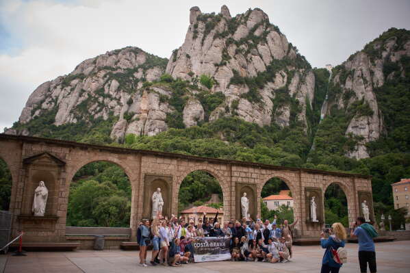 Tourists pose for a photo at the main square of the Monastery of Montserrat near Barcelona, Spain, Friday, June 5, 2026. (AP Photo/Emilio Morenatti)