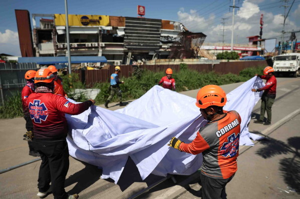 Rescuers install a tent as they prepare for a search operation following an earthquake in General Santos, Philippines, Tuesday, June 9, 2026. (AP Photo/Basilio Sepe)