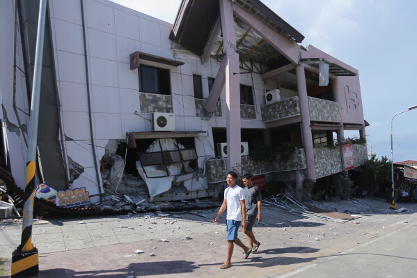 Residents pass by a collapsed structure after an earthquake in General Santos, Philippines on Monday, June 8, 2026. (AP Photo)