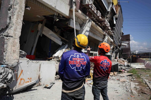 Rescuers inspect a damaged building following an earthquake in General Santos, Philippines Tuesday, June 9, 2026. (AP Photo/Basilio Sepe)