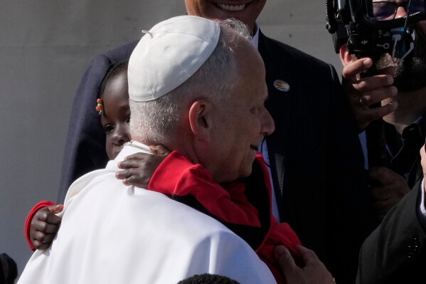 Pope Leo XIV hug a child during a meeting with migrants at the 'Las Raices' center, in San Cristobal de la Laguna, Tenerife, Spain, Friday, June 12, 2026. (AP Photo/Alessandra Tarantino)