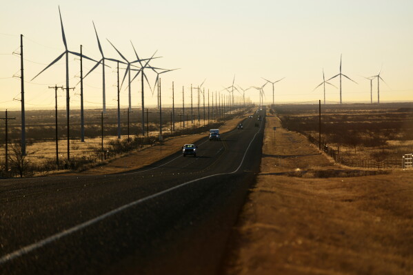 Wind turbines are visible along Route 176 as vehicles travel eastbound Feb. 24, 2025, in Andrews, Texas. (AP Photo/Julio Cortez, File)