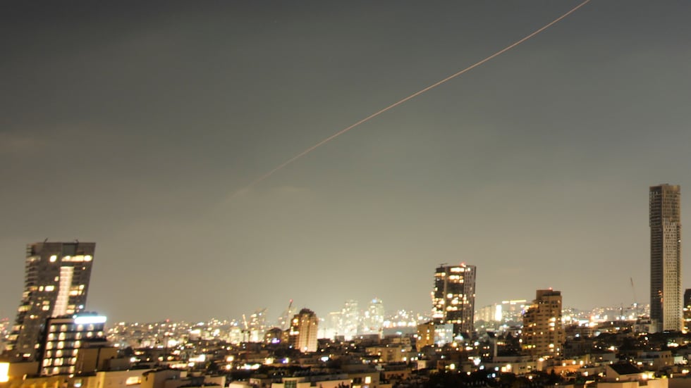 A projectile streaks through the sky over central Israel during an Iranian missile attack,...