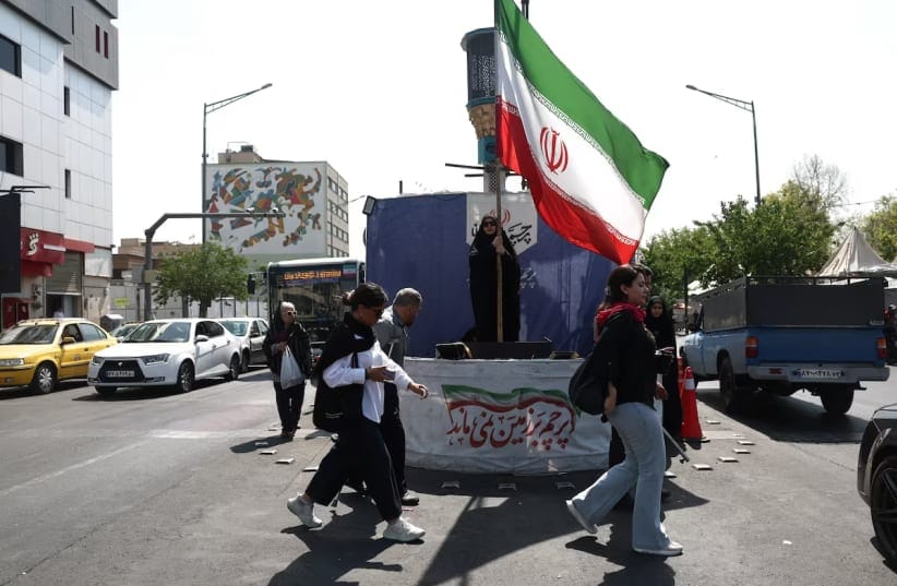 A woman holds an Iranian flag on a street in Tehran, Iran, June 10, 2026. 