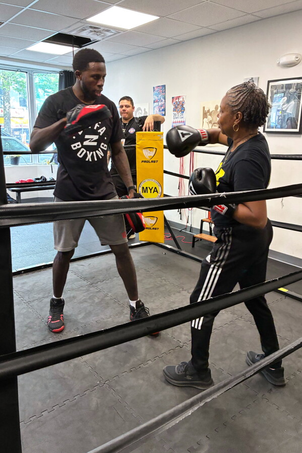 Midtown Youth Academy Executive Director Gloria Lee spars with UFC fighter Randy Brown at an event Wednesday, June 10, 2026, in Washington. (AP Photo/Fatima Hussein)