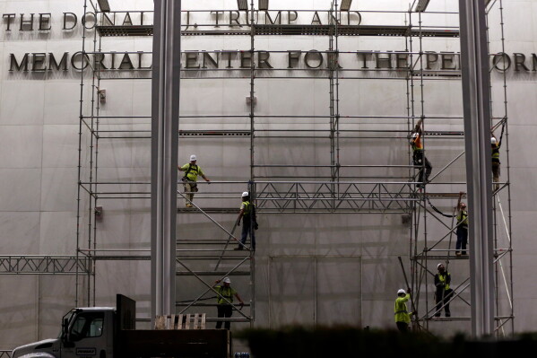 Workers construct scaffolding below the sign for the John F. Kennedy Center for the Performing Arts, Friday, June 12, 2026, in Washington. (AP Photo/Rahmat Gul)