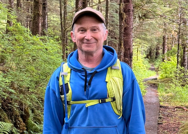 In this image provided by Karen Dillman, Alaska Senate candidate Dan Sullivan, one of the challengers to the incumbent senator, also named Dan Sullivan, poses for a photo on a hike, Sunday, June 7, 2026, on Kupreanof Island, near Petersburg, Alaska. (Karen Dillman via AP)