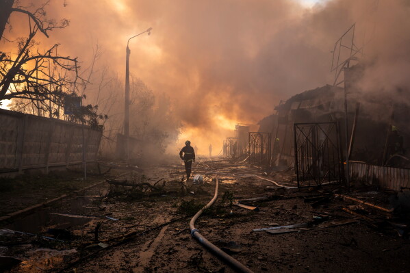 Firefighters try to put out a fire at a city marketplace following a Russian missile and drone attack in Kyiv, Ukraine, Monday, June 15, 2026.(AP Photo/Dan Bashakov)