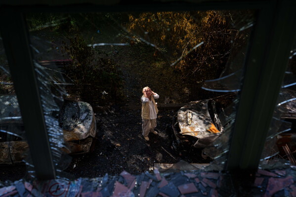 A woman reacts looking at a residential house damaged after a Russian strike on Kyiv, Ukraine, on Monday, June 15, 2026. (AP Photo/Evgeniy Maloletka)