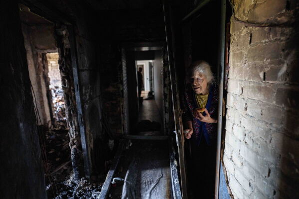 Galyna Danilova, 84, reacts while looking at a burned apartment of a residential house damaged after a Russian strike on Kyiv, Ukraine, on Monday, June 15, 2026. (AP Photo/Evgeniy Maloletka)