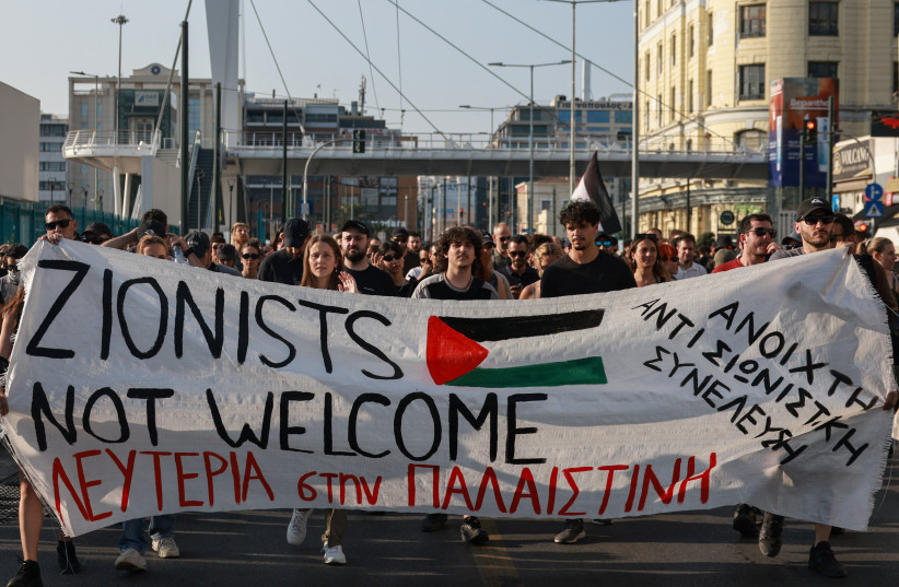 Pro-Palestinian demonstrators carry a banner during a protest against the arrival of an Israeli cruise ship in the port of Piraeus near Athens, Greece, June 12, 2025.