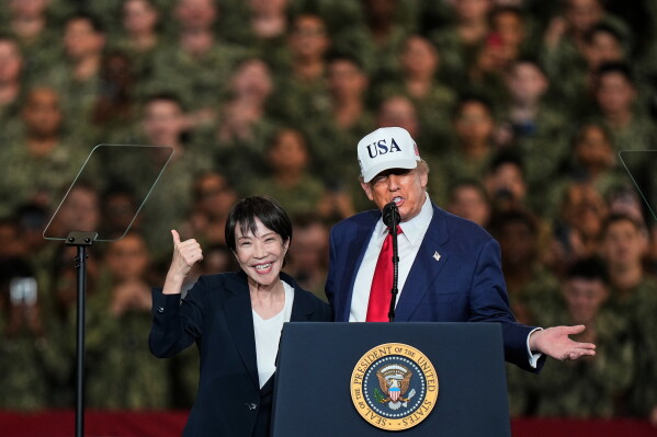 Japanese Prime Minister Sanae Takaichi gestures as U.S. President Donald Trump delivers his speech during their visit to the aircraft carrier USS George Washington at the U.S. Navy's Yokosuka base in Yokosuka, south of Tokyo, Oct. 28, 2025. (AP Photo/Eugene Hoshiko, File)