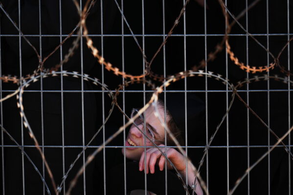 Ultra-Orthodox Jewish men protest against military recruitment and call for the release of detained draft resisters outside a military prison near Kfar Yona, Israel, Wednesday, June 17, 2026. (AP Photo/Ariel Schalit)
