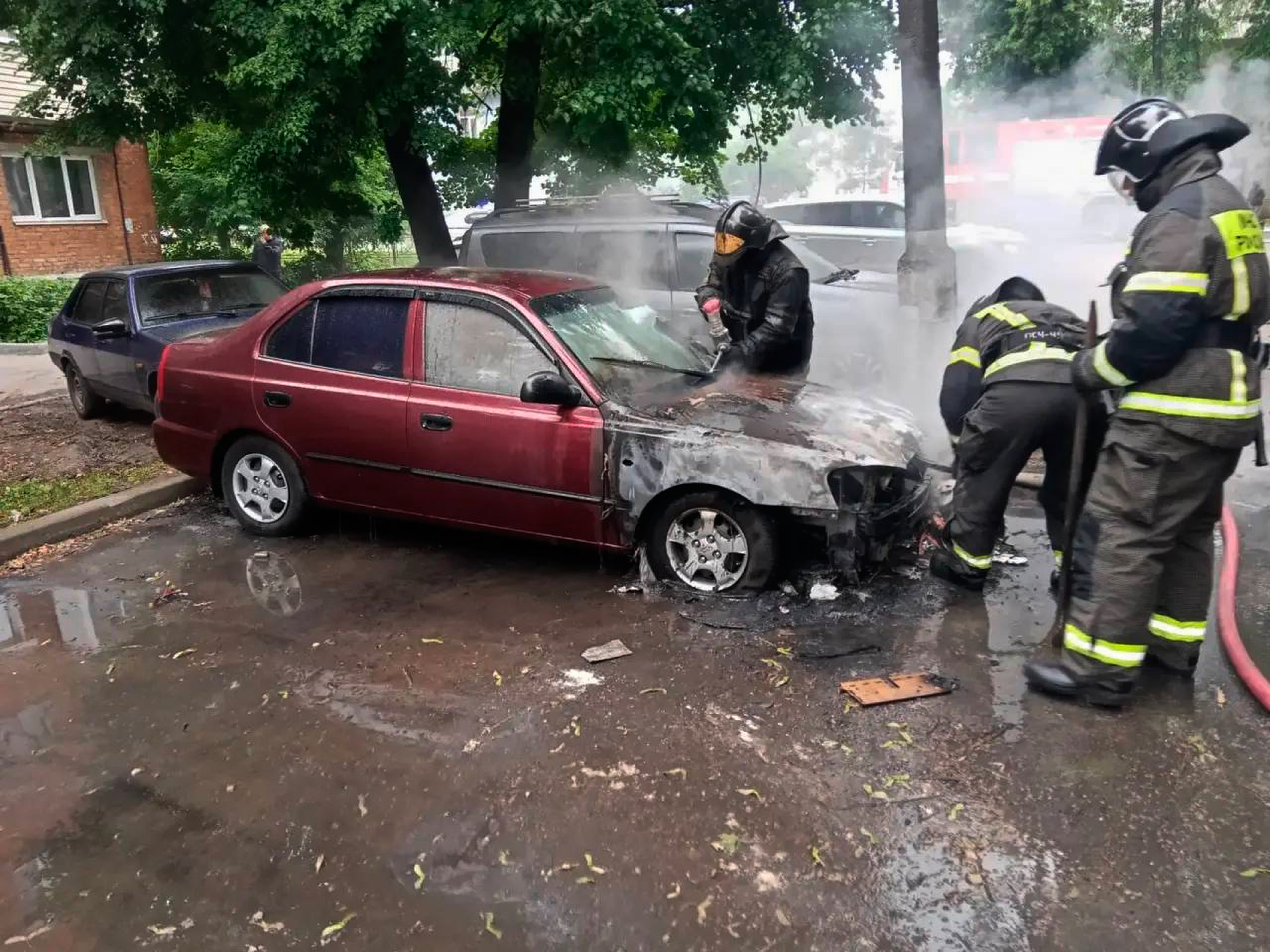 Firefighters extinguish a burning car after a Ukrainian drone attack outside Moscow