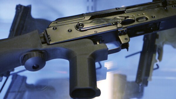 In this Oct. 4, 2017, file photo, a device called a bump stock is attached to a semi-automatic rifle at the Gun Vault store and shooting range in South Jordan, Utah. (AP Photo/Rick Bowmer, File)