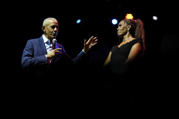 Former President Barack Obama and former first lady Michelle Obama on stage as they surprised administration and campaign alumni in Chicago ahead of the dedication ceremony of the Obama Presidential Center, Wednesday, June 17, 2026. (AP Photo/Pablo Martinez Monsivais, Pool)