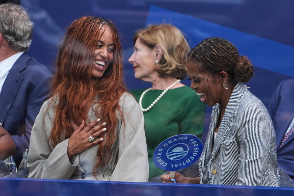 Malia Obama, left, shares a laugh with her mother, former first lady Michelle Obama, during the dedication ceremony for the Obama Presidential Center, Thursday, June 18, 2026, in Chicago. (AP Photo/Jeff Roberson)