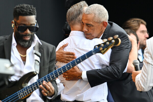 Former President Barack Obama, right, embraces Bruce Springsteen during the dedication ceremony for the Obama Presidential Center, Thursday, June 18, 2026, in Chicago. (AP Photo/Jon Cherry)