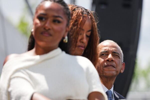 Former President Barack Obama, right, looks on from the stage during the dedication ceremony for the Obama Presidential Center, Thursday, June 18, 2026, in Chicago. (AP Photo/Alex Brandon)