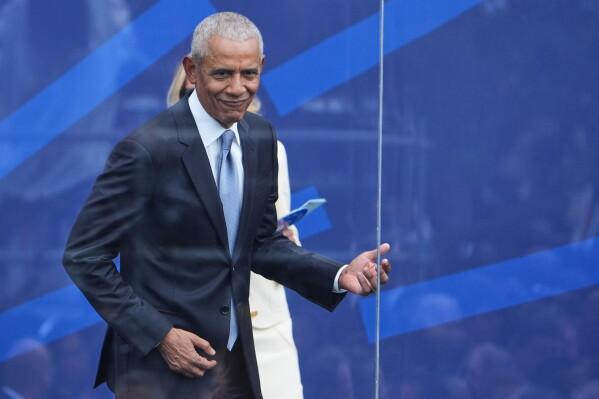 Former President Barack Obama plays air guitar during the dedication ceremony for the Obama Presidential Center, Thursday, June 18, 2026, in Chicago. (AP Photo/Jeff Roberson)