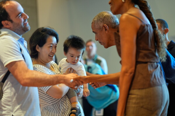 Former President Barack Obama and former first lady Michelle Obama greet the first group of visitors at the official opening of the Obama Presidential Center in Chicago, Friday, June 19, 2026. (AP Photo/Pablo Martinez Monsivais, Pool)