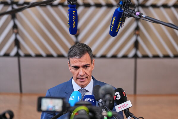 Spain's Prime Minister Pedro Sanchez talks to journalists as he arrives for the EU summit in Brussels, Thursday, June 18, 2026. (AP Photo/Marius Burgelman)