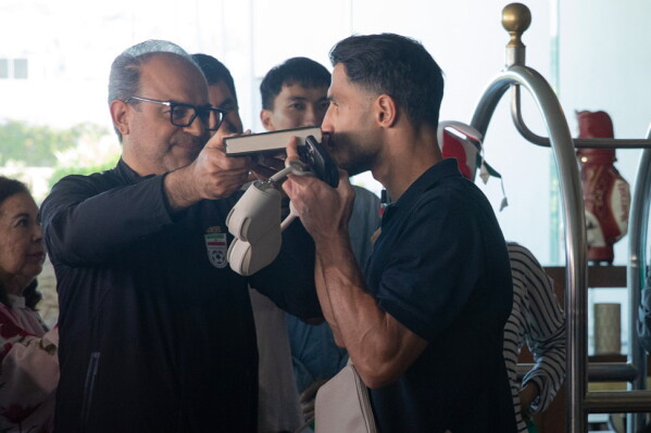 A member of the Iran national soccer team kisses the Quran as he departs from the Tijuana Marriott in Tijuana, Mexico on Saturday June 20, 2026. (AP Photo/Gabriela Aoun Angueira)