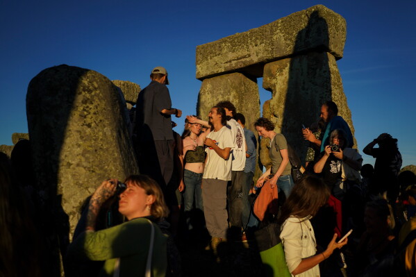 Revelers gather at the ancient stone circle Stonehenge to celebrate the summer solstice, the longest day of the year, near Salisbury, England, on Saturday, June 20, 2026. (AP Photo/Alberto Pezzali)