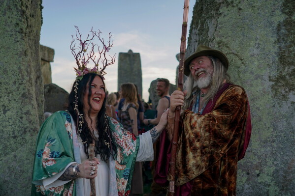 Revelers gather at the ancient stone circle Stonehenge to celebrate the summer solstice, the longest day of the year, near Salisbury, England, on Saturday, June 20, 2026. (AP Photo/Alberto Pezzali)