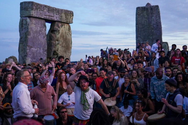 Revelers gather at the ancient stone circle Stonehenge to celebrate the summer solstice, the longest day of the year, near Salisbury, England, on Saturday, June 20, 2026. (AP Photo/Alberto Pezzali)