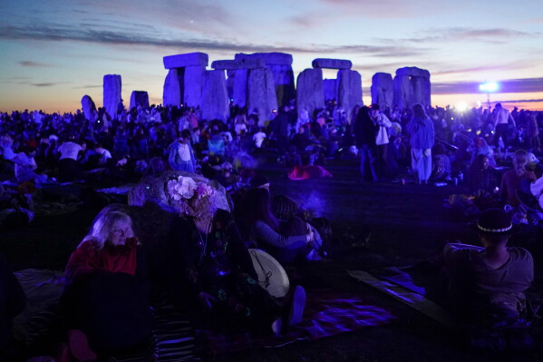 Revelers gather at the ancient stone circle Stonehenge to celebrate the summer solstice, the longest day of the year, near Salisbury, England, Saturday, June 20, 2026. (AP Photo/Alberto Pezzali)