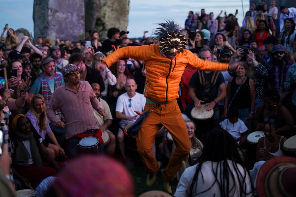 Revelers gather at the ancient stone circle Stonehenge to celebrate the summer solstice, the longest day of the year, near Salisbury, England, Saturday, June 20, 2026. (AP Photo/Alberto Pezzali)