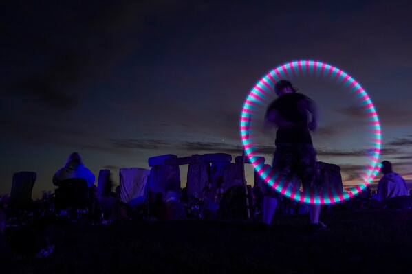 Revelers gather at the ancient stone circle Stonehenge to celebrate the summer solstice, the longest day of the year, near Salisbury, England, Saturday, June 20, 2026. (AP Photo/Alberto Pezzali)