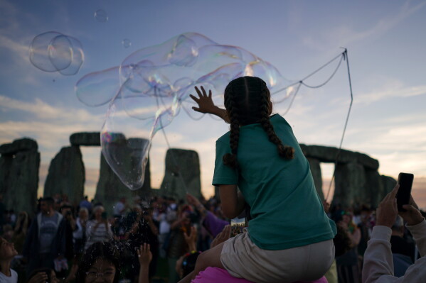 Revelers gather at the ancient stone circle Stonehenge to celebrate the summer solstice, the longest day of the year, near Salisbury, England, on Saturday, June 20, 2026. (AP Photo/Alberto Pezzali)