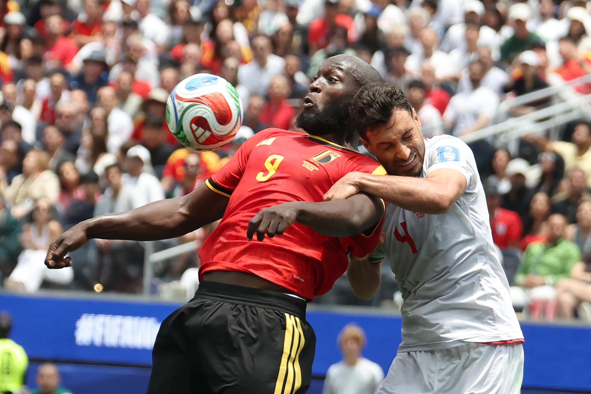 Belgium forward Romelu Lukaku, left, and Iran defender Shojae Khalilzadeh battle for the ball.