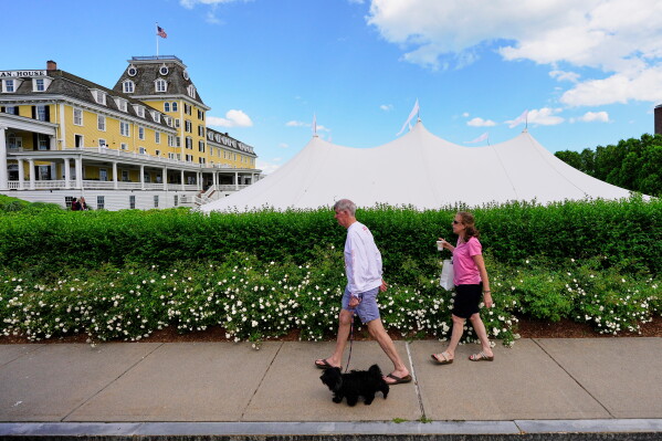 A couple walks by the Ocean House hotel where a temporary event tent prompted speculation of the possibility of Taylor Swift's impending wedding, Saturday, June 20, 2026, in Westerly, R.I. (AP Photo/Robert F. Bukaty)