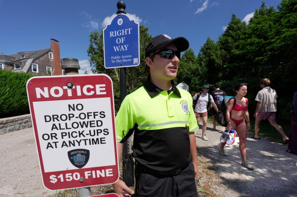 Community service officer Nick Quaratella keeps watch over beach-goers using a public path next to Taylor Swift house, Saturday, June 20, 2026, in Westerly, R.I. (AP Photo/Robert F. Bukaty)