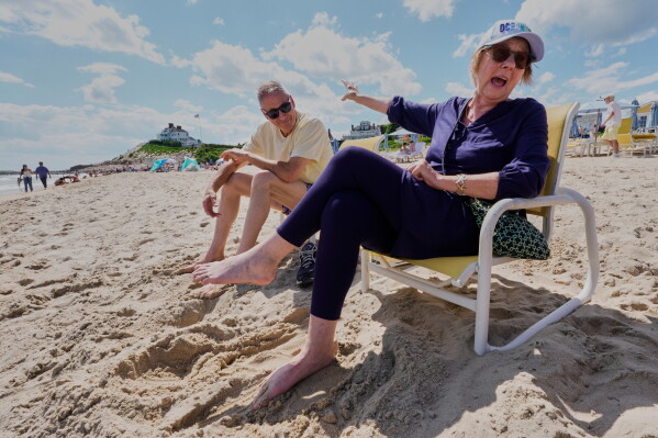 Audrey and John Curtis of Mansfield, Conn., enjoy a beach day a short distance from Taylor Swift's "Holiday House," in background, Saturday, June 20, 2026, in Westerly, R.I. (AP Photo/Robert F. Bukaty)