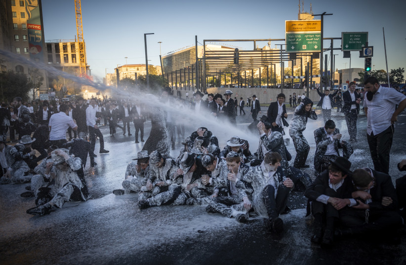 Ultra orthoodx jewish men block a road and clash with police during a protest against the jailing of yeshiva students who failed to comply with an army recruitment order, in Jerusalem, June 1, 2026.