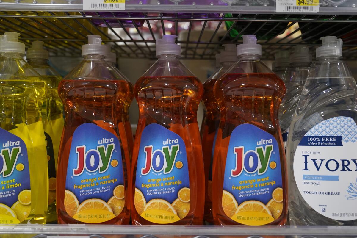 Plastic bottles on a shelf. Some have the word "Joy" on them.