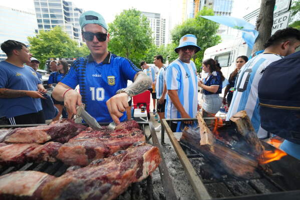 Matias Videla, of Dallas, a supporter of Argentina, checks meat on his grill during a rally ahead of his team's World Cup Group J soccer match against Austria, Sunday, June 21, 2026, in Dallas. (AP Photo/Julio Cortez)