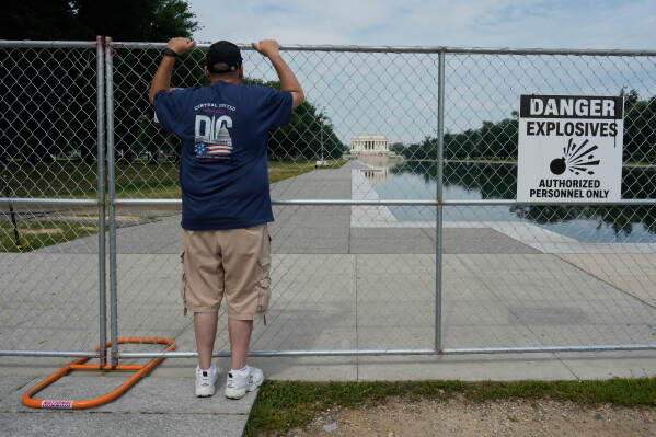 Kevin Conley looks through a chain link fence at the Lincoln Memorial Reflecting Pool and the Lincoln Memorial, Friday, June 26, 2026, in Washington. (AP Photo/Carolyn Kaster)
