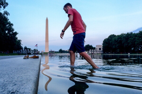 Martin Zich, of Prague, Czech Republic, wades out of the Reflecting Pool on the National Mall in Washington after going in to take photographs, May 31, 2016. (AP Photo/Andrew Harnik, File)