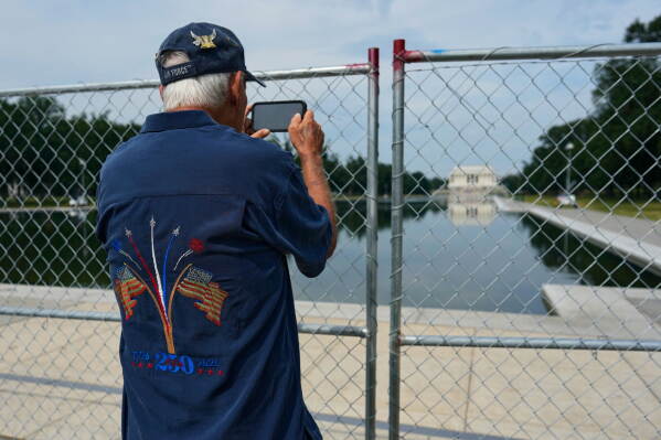 National Guard members are reflected in the water as they stand near the Lincoln Memorial Reflecting Pool, Monday, June 22, 2026, in Washington. (AP Photo/Mark Schiefelbein)