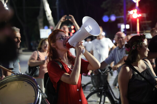 Designer Fatma Paja, center takes part in a protest against a coastal development project in western Albania linked to Jared Kushner, son-in-law of President Donald Trump, in Tirana, Albania, Friday, June 26, 2026. (AP Photo/Hameraldi Agolli)